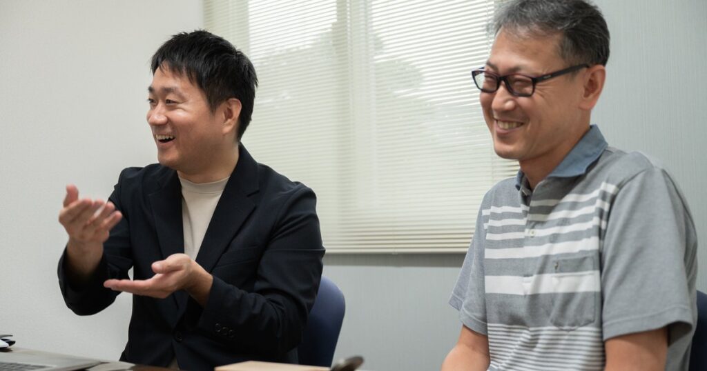笑顔で語り合う小林宏聡さんと碁盤裕之さん